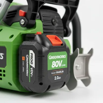 Close-up of Greenworks Pro 80V battery and safety features on the chainsaw.